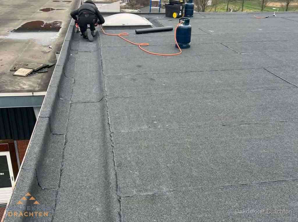 Dakdekker repareert bitumen dakbedekking op groot plat dak in Drachten Dakdekker repareert bitumen dakbedekking op groot plat dak in Drachten