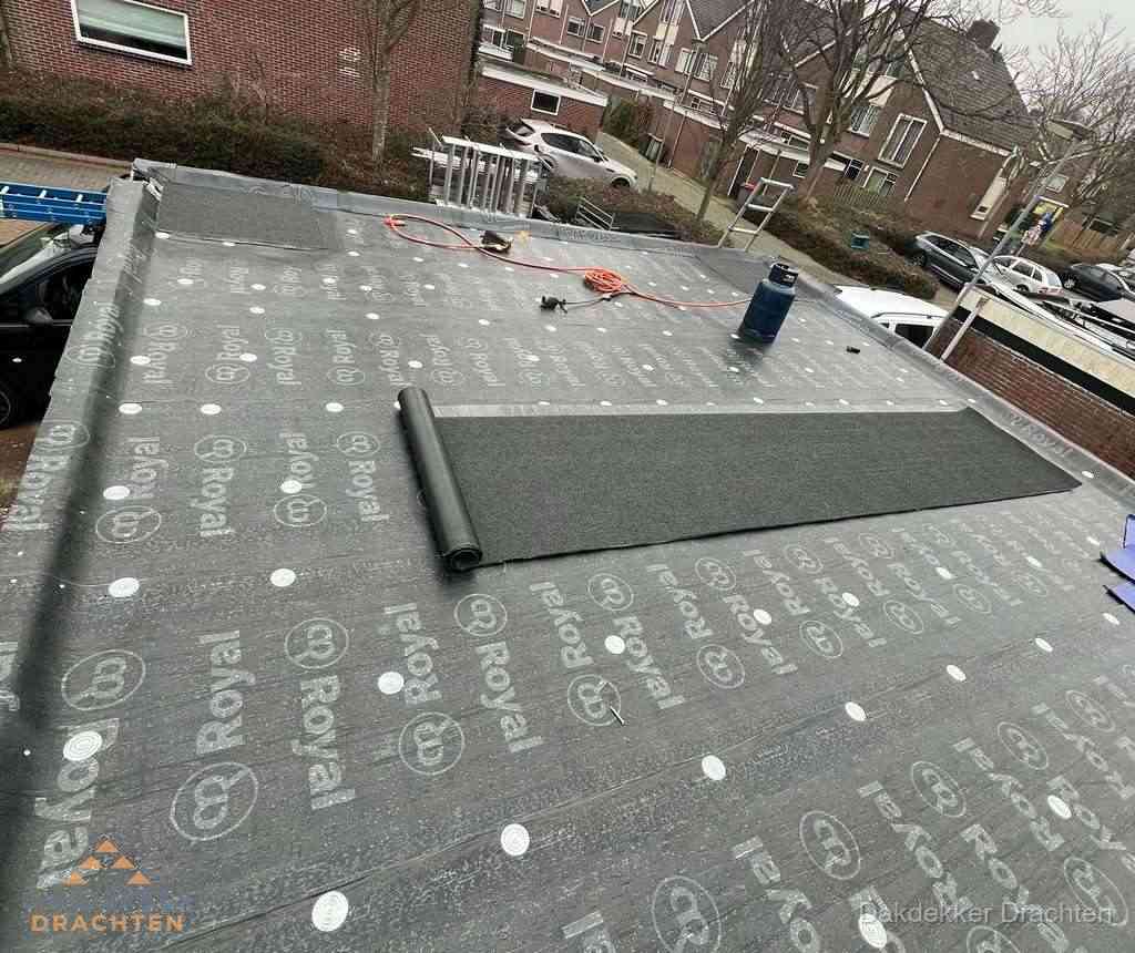 Dakdekker aan het werk met gasbrander op plat bitumen dak in Drachten Dakdekker aan het werk met gasbrander op plat bitumen dak in Drachten